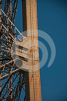 View of one legÃ¢â¬â¢s iron structure of the Eiffel Tower, with sunny blue sky in Paris. photo